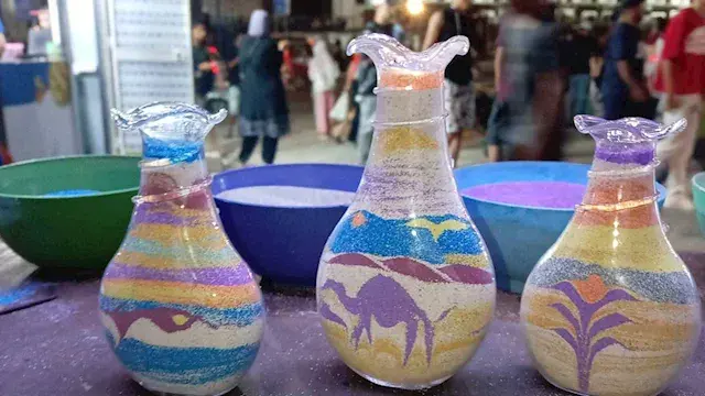 كل زجاجة تحمل حكاية.. أحمد يرسم بالرمال ليواصل علاج ابنته